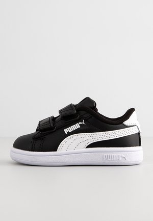 Basket Puma noir et blanc avec double fermeture velcro, logo Puma blanc et semelle blanche sur fond uni.