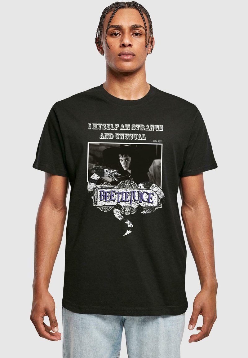 Sort bomulds T-shirt med et grafisk print med teksten "JEG SELV ER STRANDE OG UALMINDELIG" samt et billede af en karakter, udsmykket med et slangedesign.