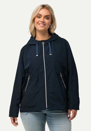 Giubbotto impermeabile blu con cappuccio, zip frontale e dettagli argentati. Presenta lacci regolabili sul cappuccio e due tasche laterali con zip.