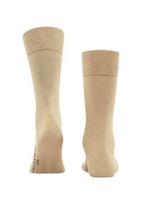 Calcetines beige hasta la rodilla con una textura suave, que cuentan con una puntera y talón reforzados, una banda superior elástica y un patrón de agarre en la suela que brinda soporte.