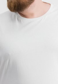 T-shirt bianco a maniche corte con scollatura rotonda, realizzato in tessuto morbido. La maglietta ha un design semplice senza motivi o accenti visibili.