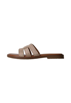 Sandale plate beige avec trois brides cloutées et une semelle marron vue de côté sur fond blanc.