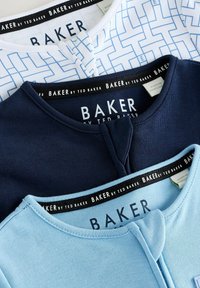 Drie opgevouwen babybody's in het wit, marineblauw en lichtblauw, elk met een ronde halslijn en een geometrisch of effen ontwerp.