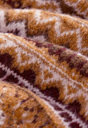 Textil din lână în tonuri calde de maron, portocaliu și crem, cu un model în zig-zag și o textură pufoasă, evidențiind detalii tricotate intricate.