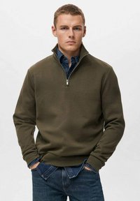 Sudadera de forro polar verde oliva con cuello con cremallera, combinada con una camisa de denim. Presenta una textura suave y puños acanalados para mayor comodidad.