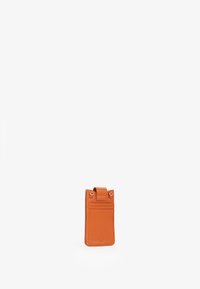 Portafoglio per carte in pelle arancione con finitura testurizzata, dotato di una patta removibile e due scomparti per carte. Design rettangolare compatto.