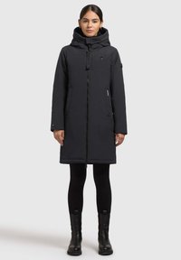 Sort knælang parka med hætte, frontlæns lynl�ås, sidelommer og en glat mat overflade. Har minimal branding.