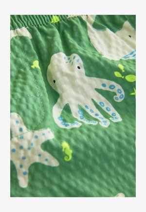 Țesătură verde cu un model texturat cu caracatițe albe, stele de mare și căluți de mare, accentuate de detalii albastre și galbene. Talie cu elastic.