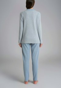 Set di pigiama blu chiaro con un motivo a spina di pesce testurizzato. Maglietta a maniche lunghe e pantaloni dritti con una vestibilità comoda. Tessuto leggero.