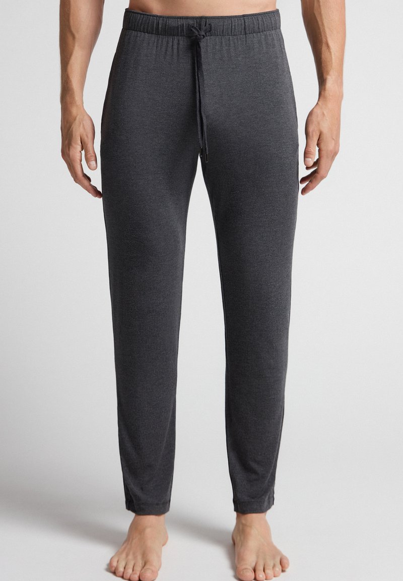 Donkergrijze loungebroek voor heren, gemaakt van zachte stof, met een elastische tailleband en een trekkoord, en taps toelopende benen.