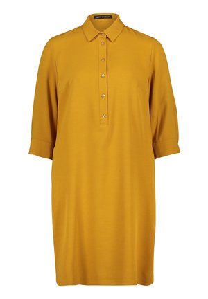 Hořčicově žluté šaty ke kolenům s límečkem, tříčtvrtečními rukávy a légou se zapínáním na pět knoflíků vpředu.