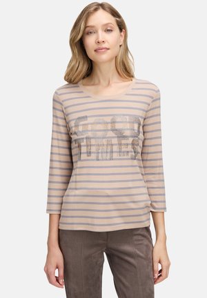Beige langærmet T-shirt med grå striber, rund halsudskæring og palietteret "GOOD TIMES" tekst på tværs af forsiden. Blødt, let stof.