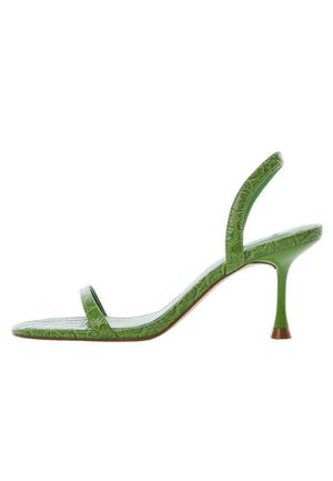 Zielony sandał na wysokim obcasie z cienkimi paskami i teksturowanym wykończeniem o wzorze krokodyla, przedstawiony na białym tle.