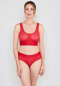 Red lace bralette with wavy pattern and wide band. Matching red lace hipster panties with elastic waistband. Soft texture, seamless design.