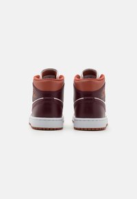 Hög-top sneakers i djup mörkröd läder med en blekrosa krage. Har vit mellansula, gummisulor och präglad logotypdetalj.