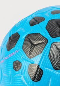 Μπλε ποδοσφαιρική μπάλα με εξαγωνικά μαύρα σχέδια, με υφή στην επιφάνεια και ροζ σήμανση "ACADEMY". Φέρει τον αριθμό 25/26 σε ένα εξάγωνο.