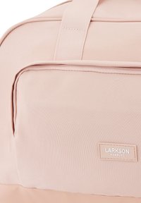 Ružový látkový cestovný batoh s prednou zipsovou kapsou, s plochými popruhmi a logom "LARKSON HAMBURG". Hladký povrch.