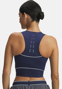 Marineblå sports-bh med højt rygdesign, hvide accentlinjer, perforerede sektioner for åndbarhed og et elegant design uden ekstra hardware.