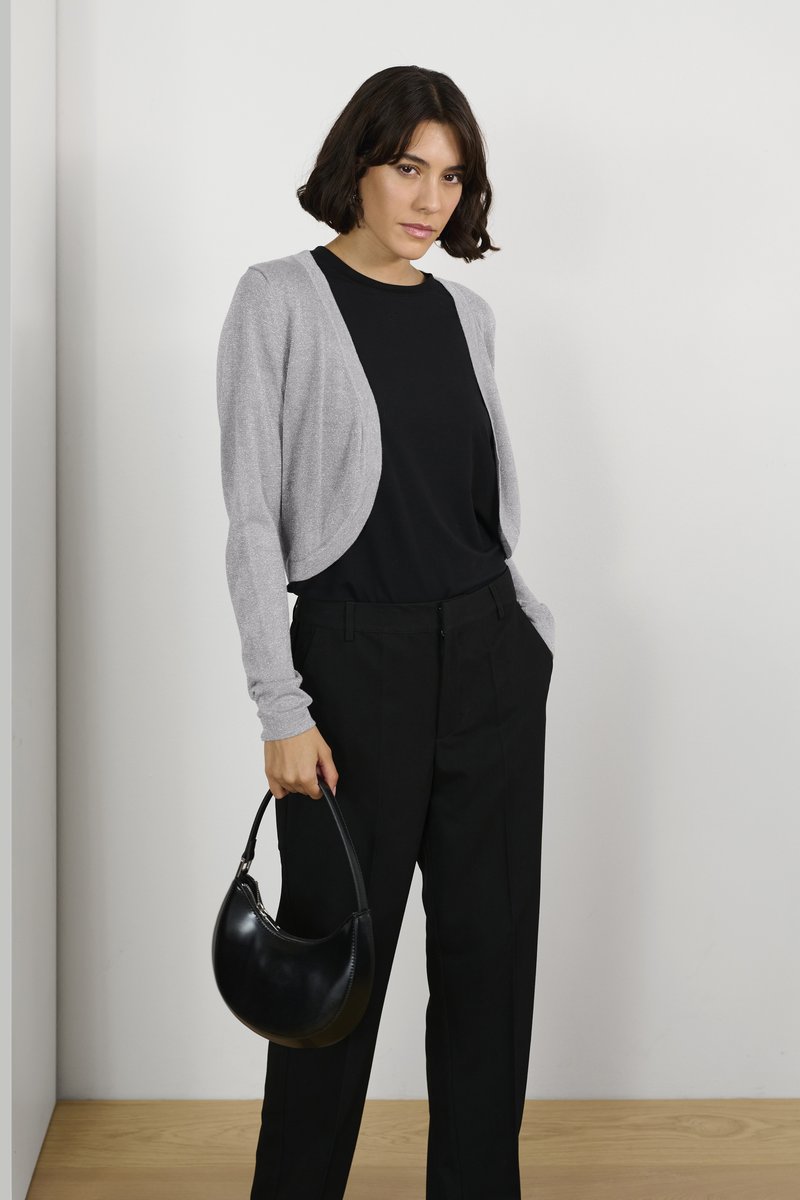 Gray cardigan with a soft texture, paired with a black top and black trousers. Holding a round black handbag. Minimalist design.