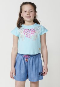 Svetlo modra majica s kratkimi rokavi s dizajnom srca in kril. Denim kratke hlače z roza vrvico in vezenim detajlom mačke.