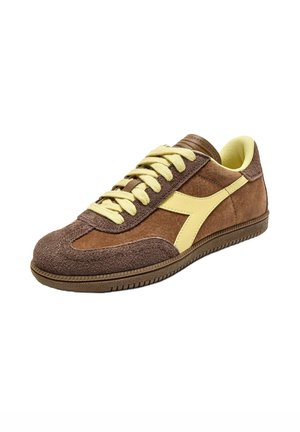 Sneaker marroni e gialli con materiale in suede, punta rotonda, design con lacci e suola in gomma texturizzata con accentuazione del logo in contrasto.