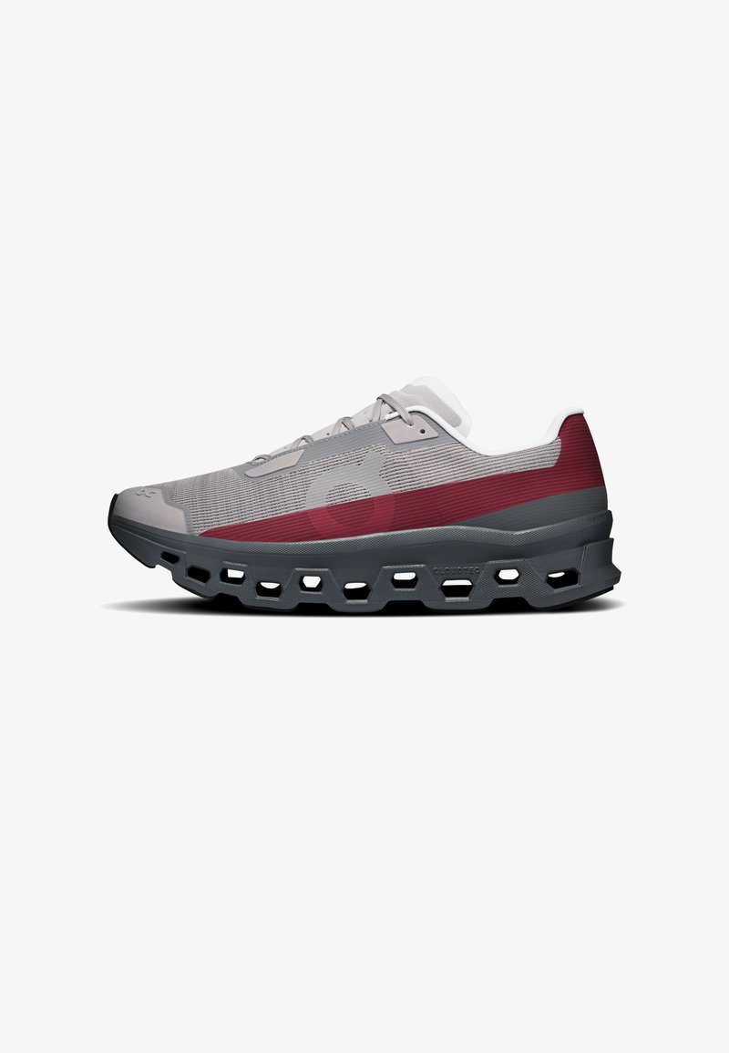 Chaussure de sport grise et bordeaux avec des lacets blancs, profil bas, et semelle foncée épaisse et ventilée, avec des découpes hexagonales.
