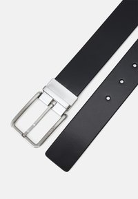 Cintura in pelle nera con fibbia in metallo argentato, caratterizzata da un design rettangolare e multiple fori di regolazione lungo la sua lunghezza.