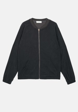 Fekete kordbársony dzseki, elöl cipzárral, két oldalsó zsebbel, bordázott mandzsettával és kerek nyakkal. Puha tapintású, csíkos mintával.