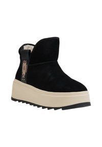 Stivali ankle in suede nero con suola piatta crema, caratterizzati da una cintura decorativa con embellishments colorati e una fodera in tessuto morbido.