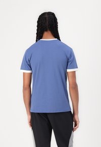 Modré tričko s krátkým rukávem z bavlny s kulatým výstřihem, zdobené bílými doplňky na rukávech a límci, hladká textura.