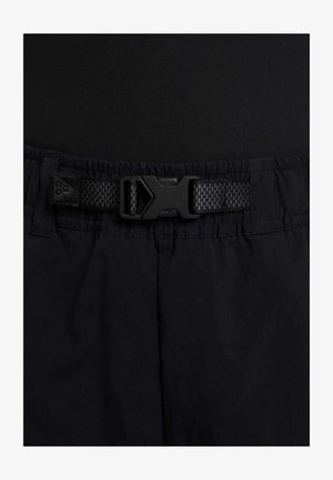 Černé šortky s texturovanou tkaninou, elastickým pasem a černým nastavitelným pásem s plastovou sponou pro bezpečné uchycení.