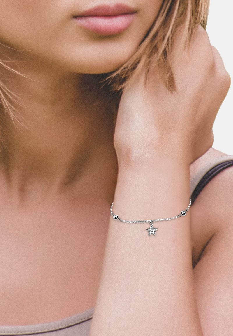 Justerbart silverarmband med en stjärnhänge och två runda pärlor, som har en delikat kedjedesign och en polerad yta.
