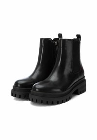Botas de ante negras hasta el tobillo con paneles laterales elásticos, suela texturizada negra, diseño robusto y cierre de cremallera. Acabado suave con un aspecto brillante.