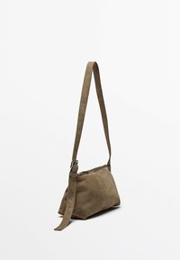 Borsa a tracolla in suede marrone con chiusura a zip, forma morbida, tracolla regolabile e texture liscia. Design minimalista senza decorazioni.