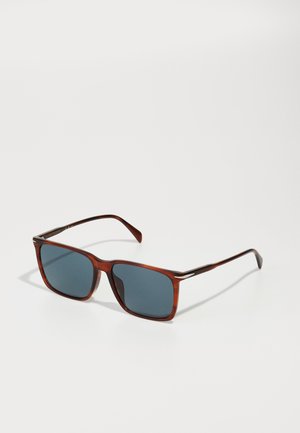 Ochelari de soare tortoiseshell maro cu lentile pătrate, lentile tintate de culoare albastru închis și accente subțiri metalice pe brațe.