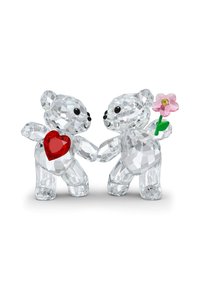 Kristallteddy-björnar, en med ett rött hjärta och den andra som håller en rosa blomma, har intrikata fasetter och genomskinliga texturer.