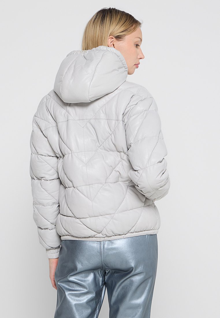 Chaqueta acolchada gris claro con capucha, con un diseño de rombos. Textura suave y lisa con puños y dobladillo elásticos.