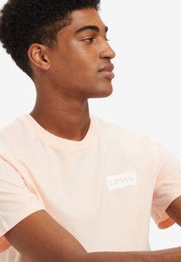 Levi's® GRAPHIC CREWNECK TEE - Camiseta estampada - pale peach