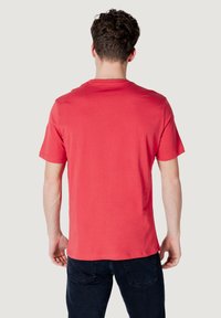 T-shirt in cotone rosso con maniche corte, collo tondo e vestibilità comoda. Texture liscia, design semplice e orlo dritto.