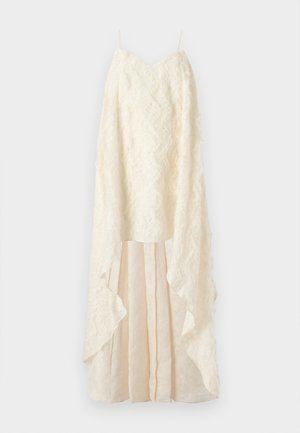 Cream-colored dress with a textured lace overlay, deep V-neck, and flowing layered skirt with an uneven hem. Adjustable thin straps.