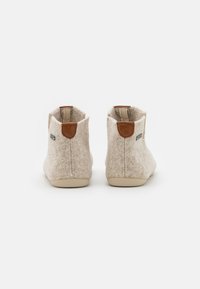 Woolen ankle boots in light beige with brown leather accents and a rubber sole. Features a clean, minimal design and rounded toe.