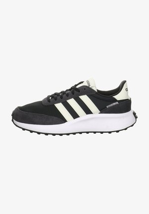 Zapatillas deportivas negras y grises con parte superior de malla, detalles de gamuza, tres rayas blancas y una suela intermedia blanca con una suela exterior texturizada en negro.