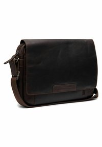 Dark brown leather messenger bag with a flap closure, adjustable strap, and front pocket. Smooth texture and minimalist design.