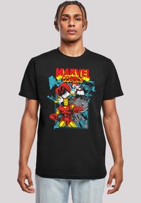 Juodas medvilnės marškinėliai su spalvingu Marvel Comics grafiku, kuriame pavaizduoti superherojai Šarvuotis, Toras ir Hulkas komiksų stiliumi.