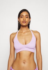 Top cropped lilás canelado com decote em V profundo, alças finas e detalhes amarelos contrastantes. Textura suave, design justo.