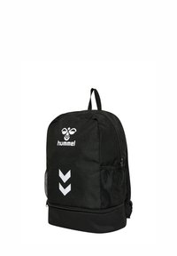 Zwarte Hummel rugzak met wit bijenlogo, twee naar beneden gerichte chevrons, zijvakken van gaas en een ritsvak aan de onderkant.