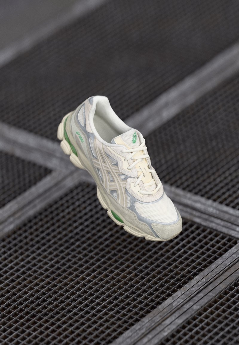 Sneaker, mille kreemi ja heledat halli võrgukatet, roheliste detailidega ja turske tallaga, millel on paeltega kinnitamine ja hingav tekstuur.