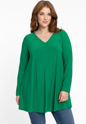 Tunique longue à manches longues de couleur verte avec un décolleté en V, fabriquée en tissu lisse. Présente une coupe décontractée et un léger évasement vers l'ourlet.