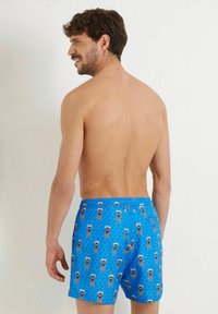 Șorturi de înot cu un model albastru, având un design cu valuri și salvamari în stil cartoon. Realizate dintr-un material ușor, cu talie elastică și șnur de ajustare.
