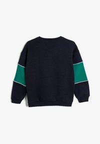 Sudadera de color azul marino oscuro con mangas verdes y detalles en blanco. Presenta un cuello redondo y puños acanalados. Tejido suave, ajuste relajado.